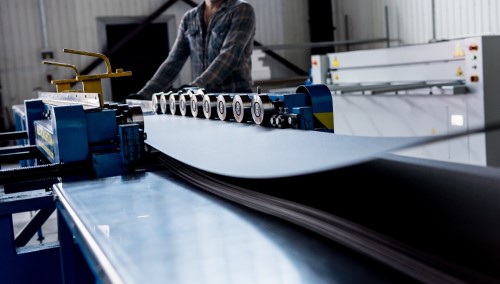 worker handling low carbon steel sheets